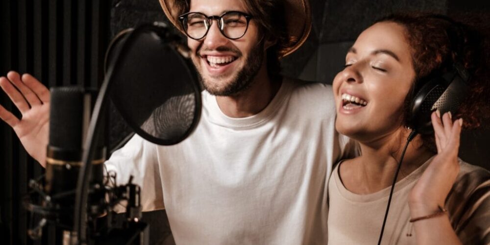 Portrait of young attractive man and woman happily singing toget